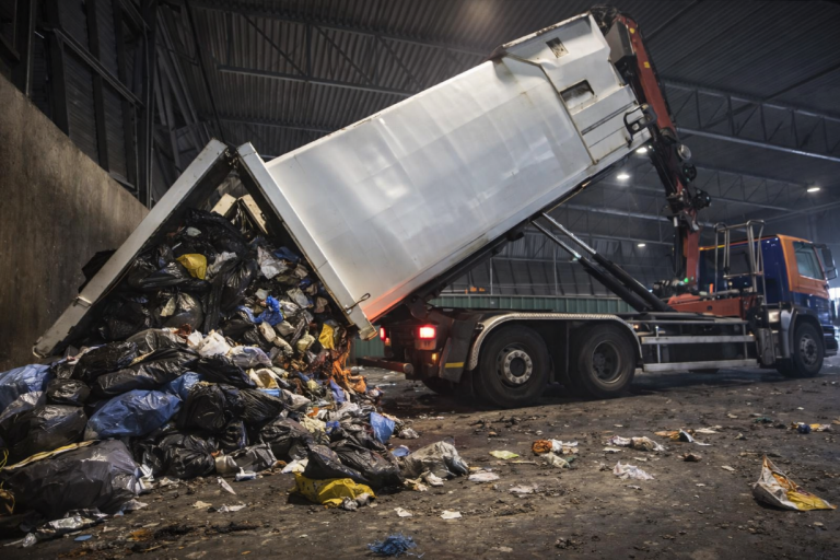 Afvalwagen stort vuil